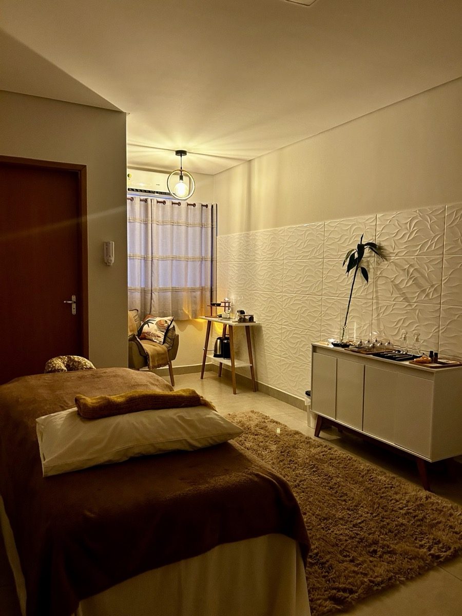 Sala de atendimento aconchegante do Ka-Lum Studio, com maca, poltrona e iluminação suave